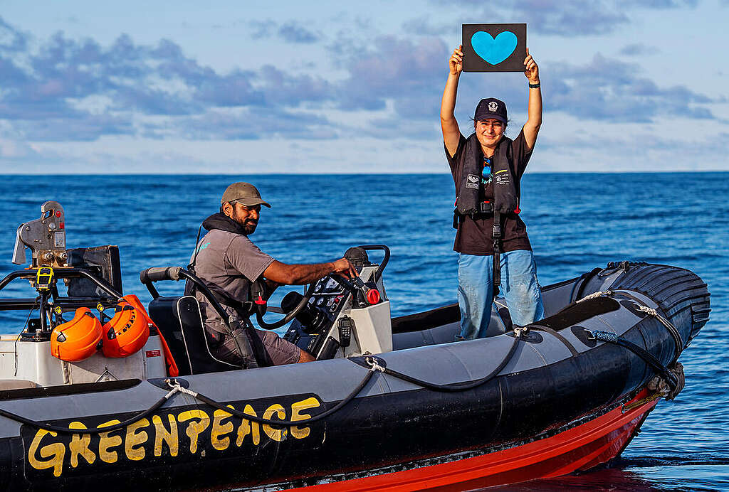 Greenpeace International activist, Alice holds a sign with a blue heart as a thank you to supporters from a RHIB in the Pacific Ocean. The Greenpeace ship is in the Pacific to bear witness to the deep sea mining industry. Part of the ongoing 'Protect the Oceans' campaign.