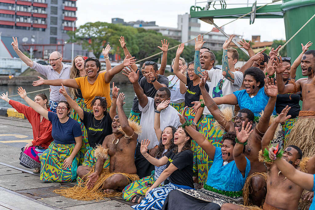 Crew and Dulali Traditional Meke Group in front of the Rainbow Warrior in Fiji. © Greenpeace / The Roving Rovas