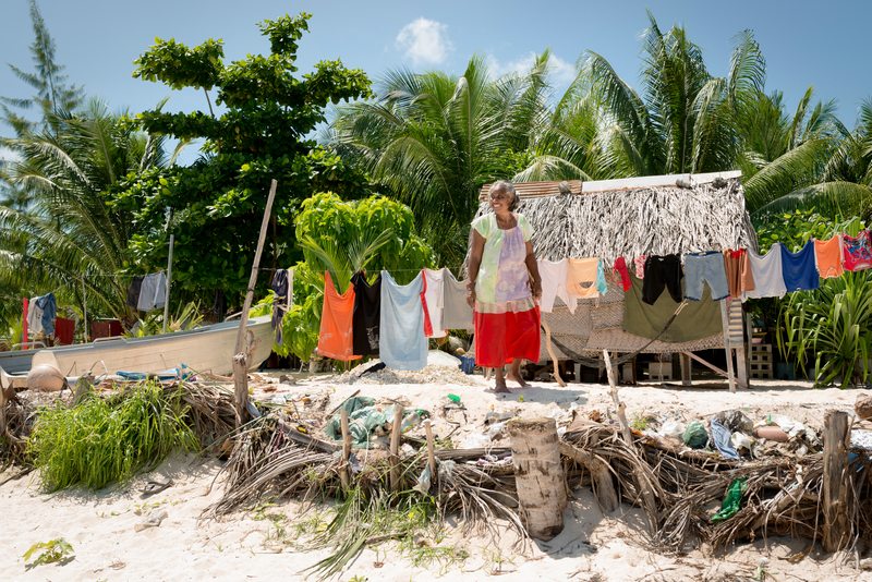 A woman outside of her home in a fishing village near Betio in Kiribati