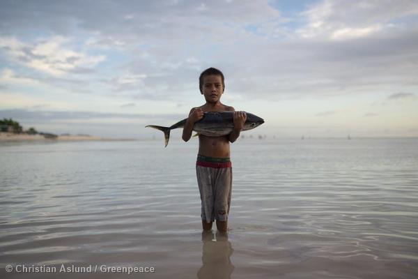 Boy with Tuna Fish Stands in Sea