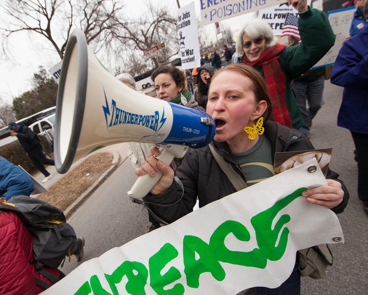 A Greenpeace supporter uses a megaphone to make clear her thoughts during the march. Tens of thousands of people gathered at Shaw University in downtown Raleigh. The march travelled to the doorstep of the State Capitol. Each year this fusion movement comes together in February to hold a mass people's assembly to reaffirm its commitment to the 14 Point People's Agenda and to hold lawmakers accountable to citizens.