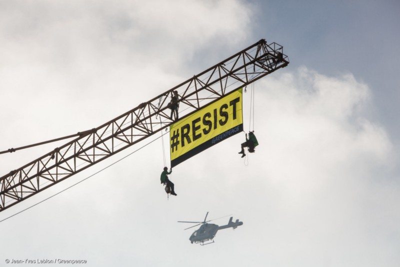 On a crane in front of the US Embassy, 5 activists from Greenpeace Belgium put a banner saying RESIST while Trump is in Brussels visiting the NATO