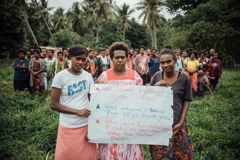 Women Hold Signs at ICJ AO Action in Tanna, Vanuatu