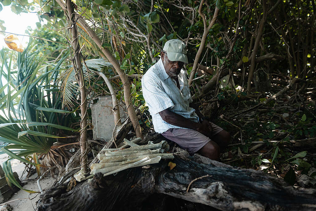 A man observes the community graveyard impacted by coastal erosion on Pele Island in Vanuatu.